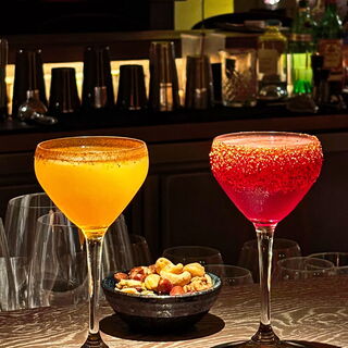 two cocktails at the bar with nuts