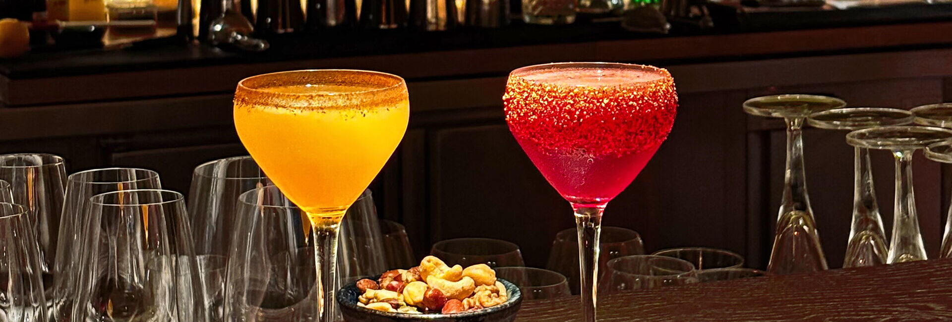 zwei Cocktailgläser auf dem Tresen mit Nüssen
