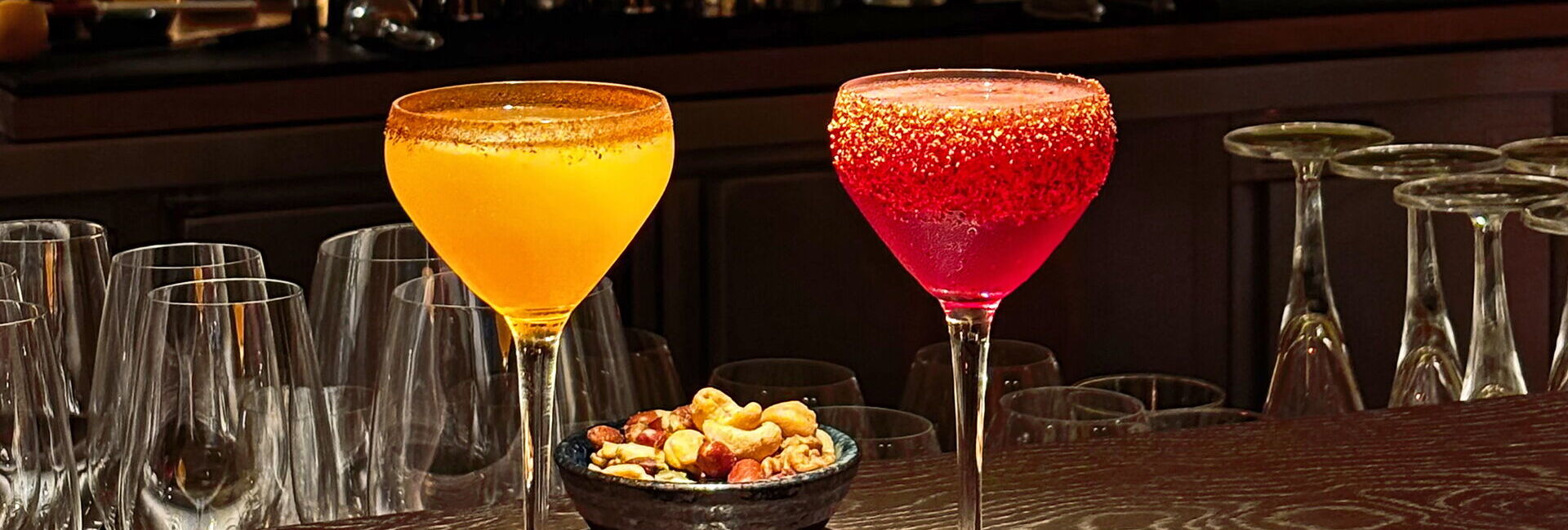 zwei Cocktailgläser auf dem Tresen mit Nüssen